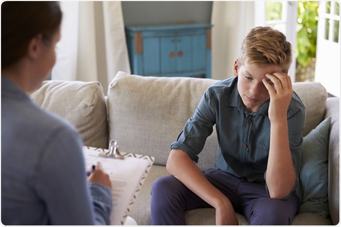 Teenage Boy With Problem Talking With Counselor At Home Teenage Boy With Problem Talking With Counselor At Home