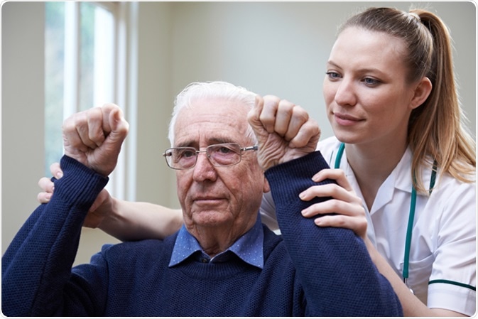 Nurse Assessing Stroke Victim By Raising Arms. Image Credit: SpeedKingz / Shutterstock