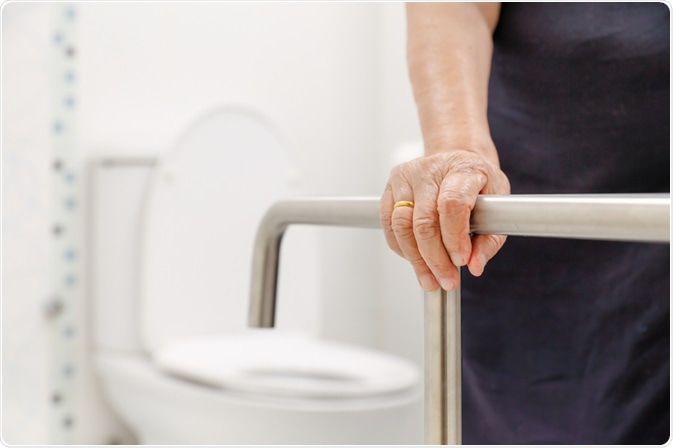 Elderly person holding old fashioned hand rail