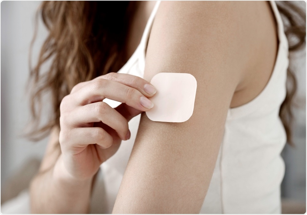 Woman applying contraceptive patch to arm - By Image Point Fr