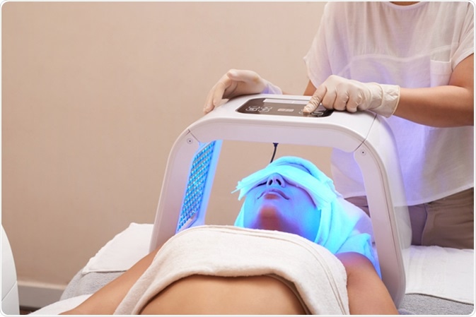 Cosmetologist setting LED lamp for color light therapy. Image Credit: Dragon Images / Shutterstock