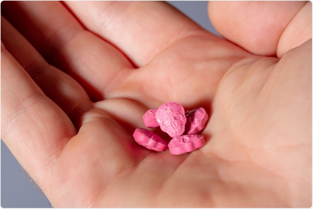 MDMA, shown here as pink pills, has been shown to improve PTSD symptoms, by connecting with social reward systems in the brain.