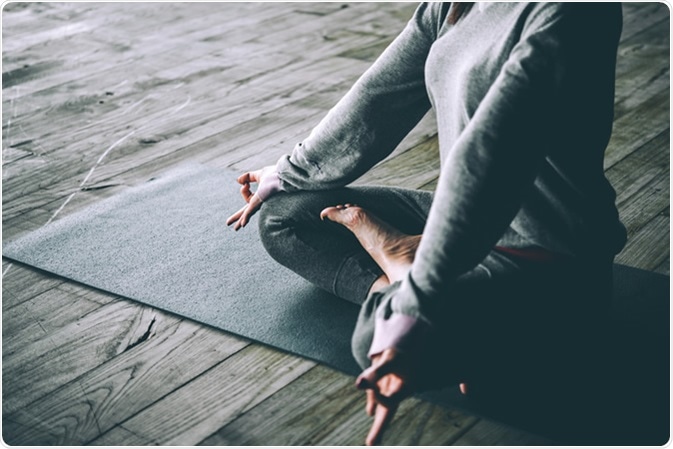 Young woman meditates while practicing yoga. Credit: Yulia Grigoryeva / Shutterstock