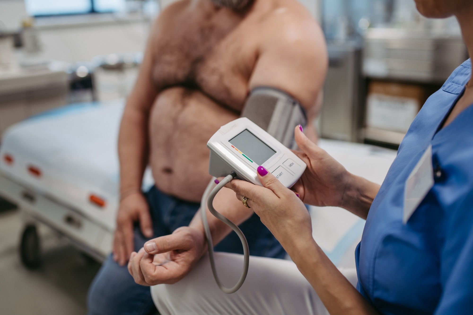 Nurse obtaining blood pressure from overweight man