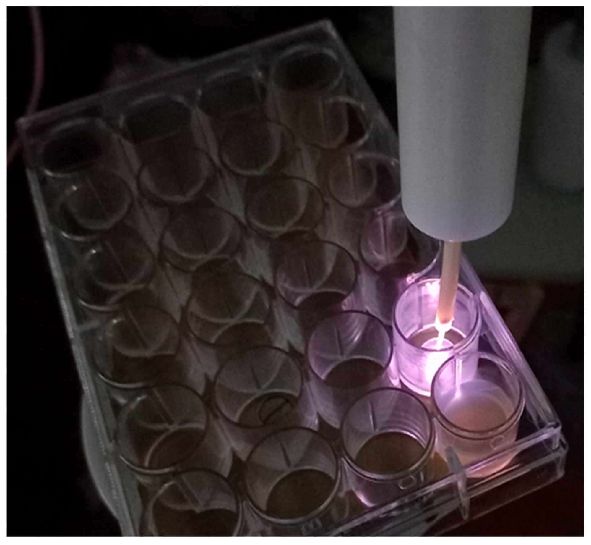 Cold atmospheric plasma jet emitting a violet glow into a sample well of a 24-well laboratory plate.