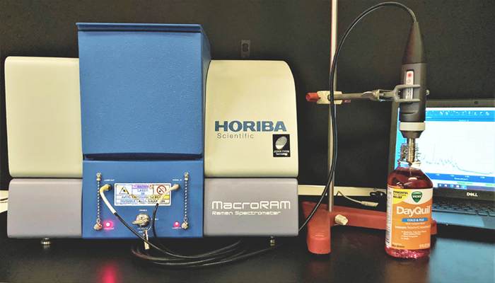 Raman spectra of DayQuil™ and NyQuil™ collected with an immersion probe fiber-coupled to the MacroRAM™ Raman spectrometer, and a picture of the immersion probe setup