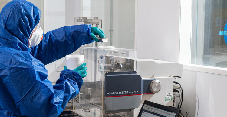 Scientist wearing PPE using Hosokawa Micron equipment