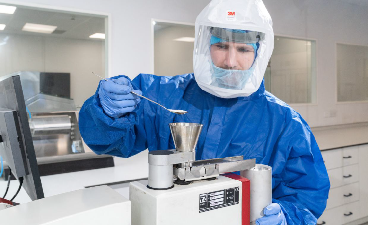 Male scientists wearing PPE performing powder processing