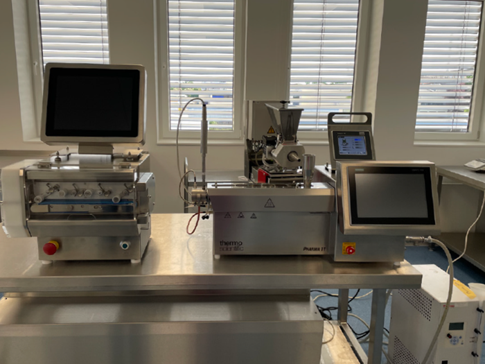Extrusion setup for hollow tube extrusion with Pharma 11 twin-screw extruder, gravimetric RotoTube feeder, Pharma 11 catheter die, and pulling and cutting to the required length and diameter control via the CaliCut post-extrusion system