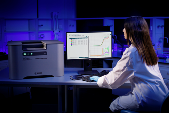 Female scientist wearing a lab coat looking at data on a PC