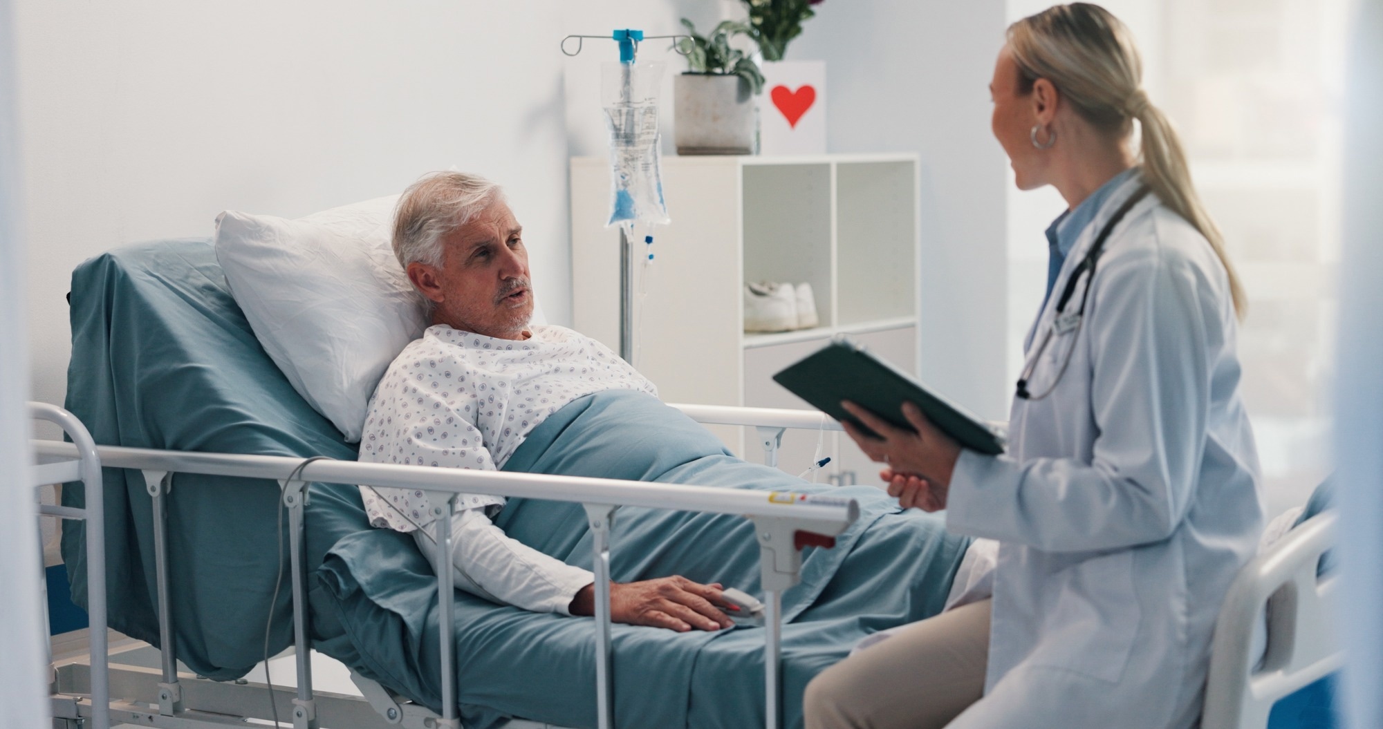 Doctor with tablet, consulting and old man in hospital bed for healthcare, diagnosis or test results.