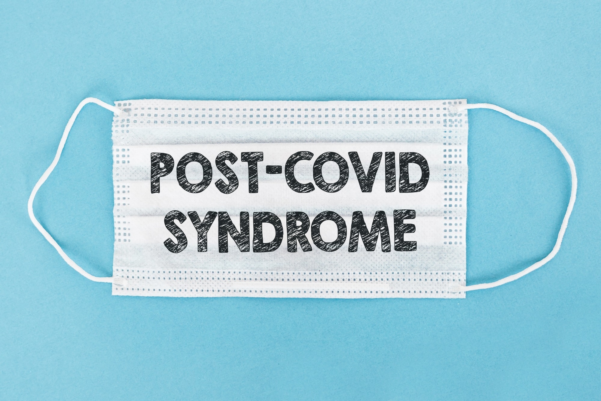 Medical face mask with POST-COVID SYNDROME text on blue background.