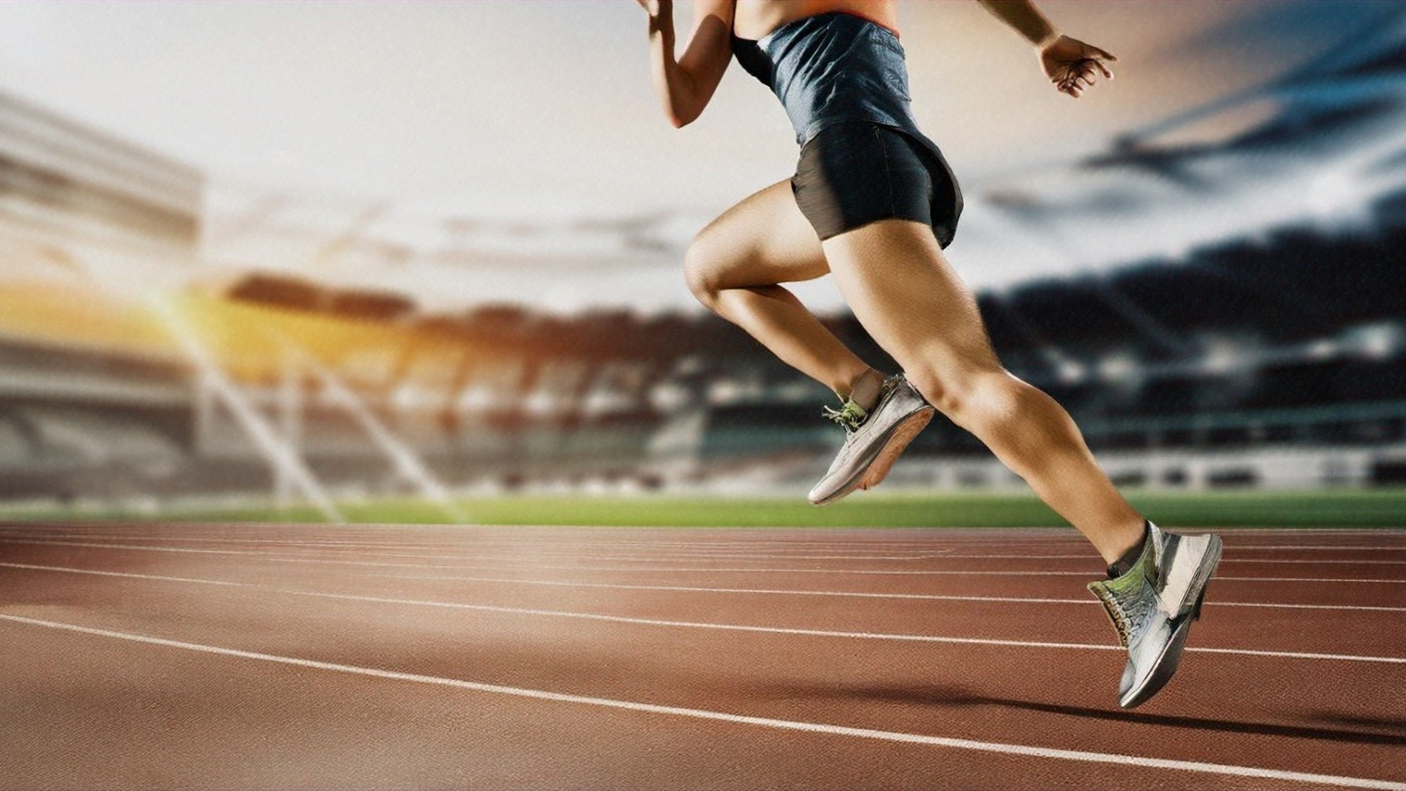 runner reaching the finish line on an athletics track. The focus of the photo is on the feet and the shot is from the side