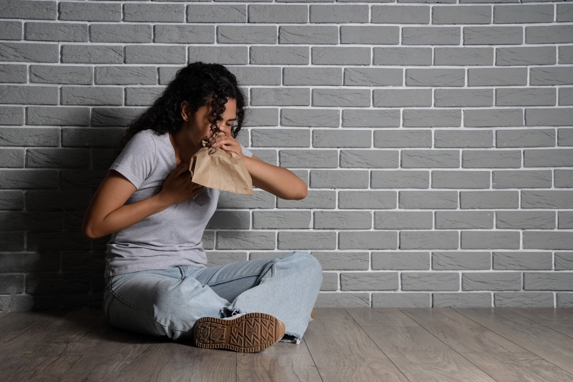 Young African-American woman having panic attack in room
