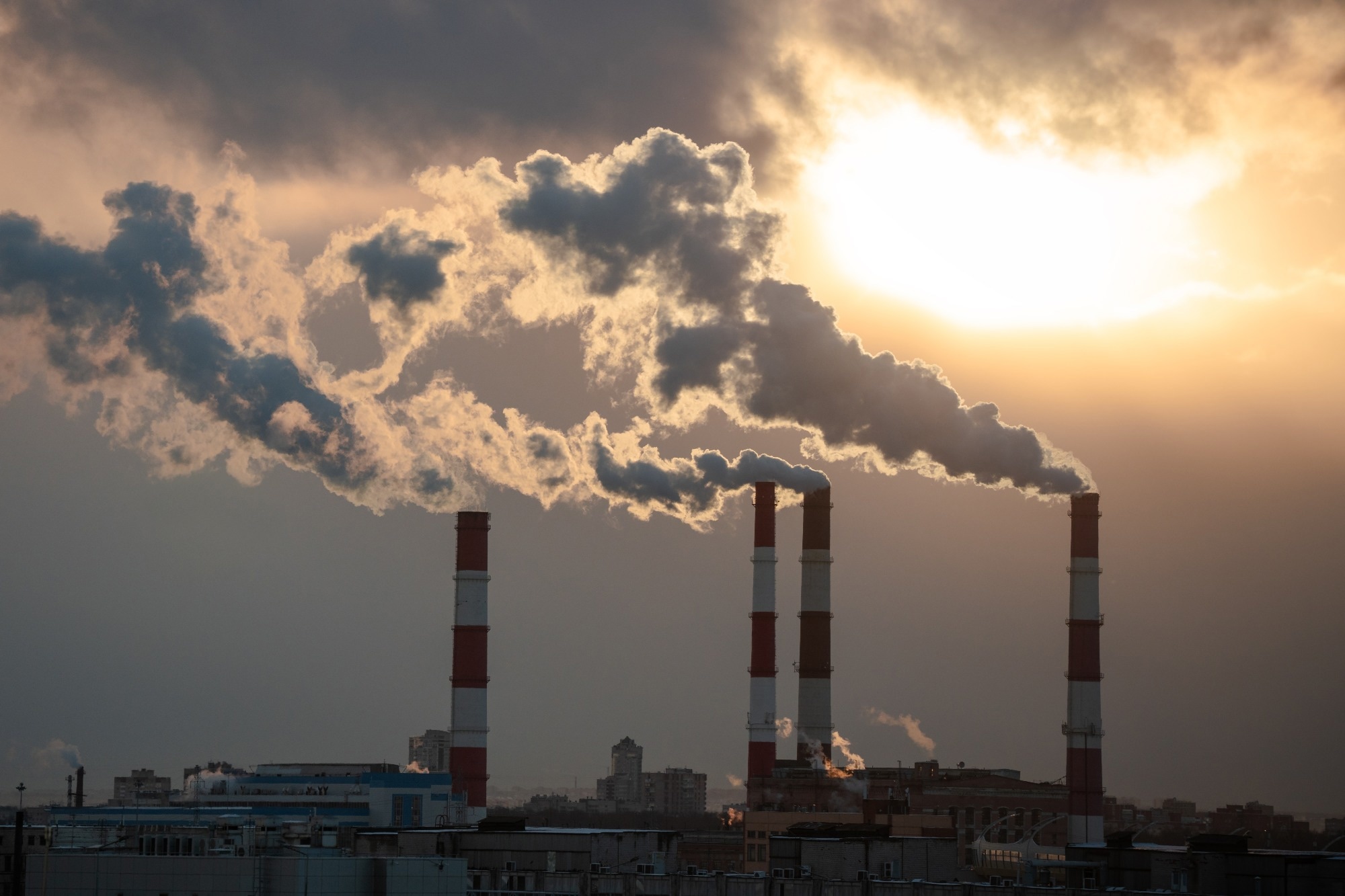 Smoke from factory pipe of heat station in the city in winter time.