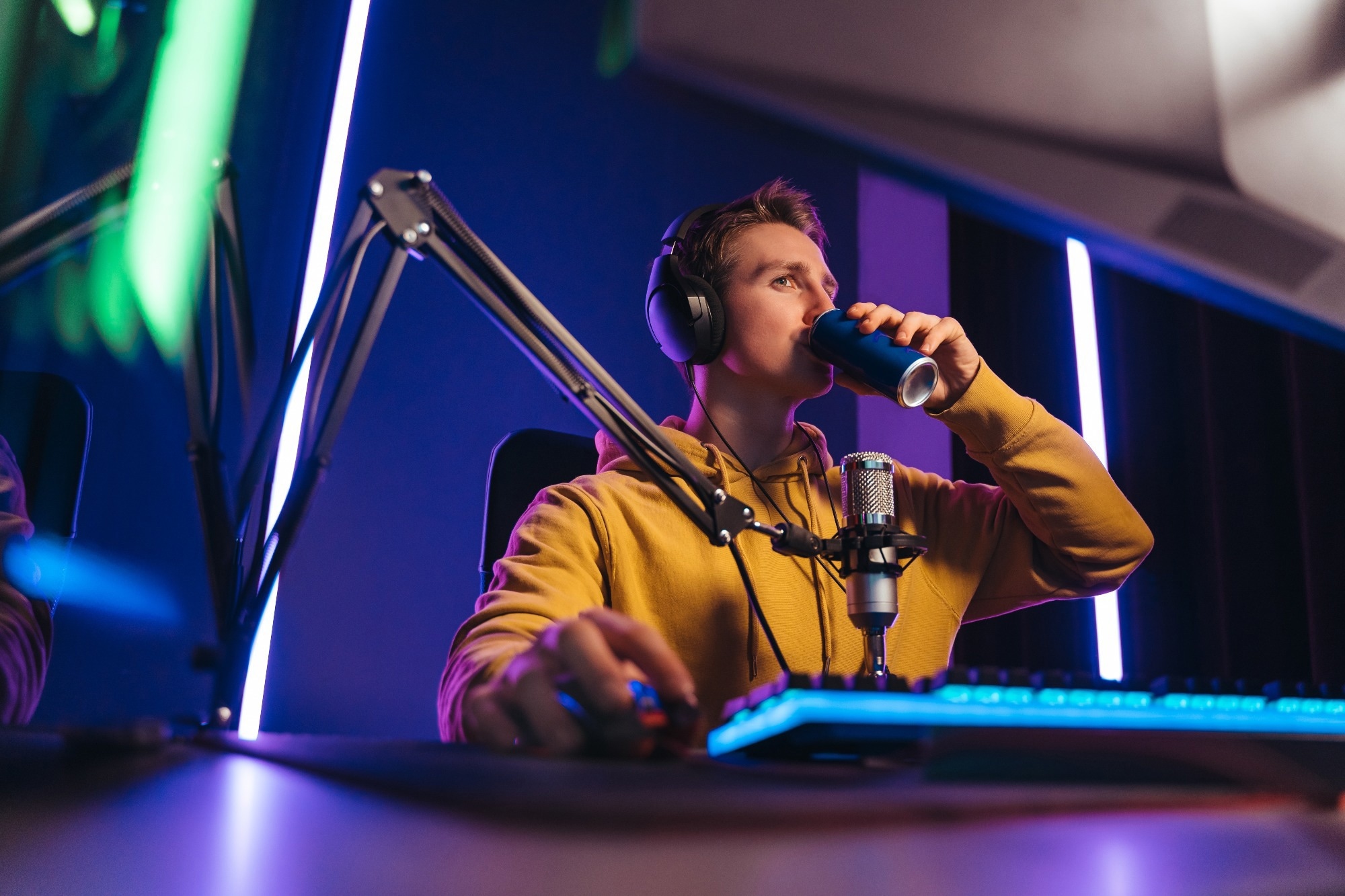 Professional cyber sportsman drinking out of can to wake up and concentrate on computer game.