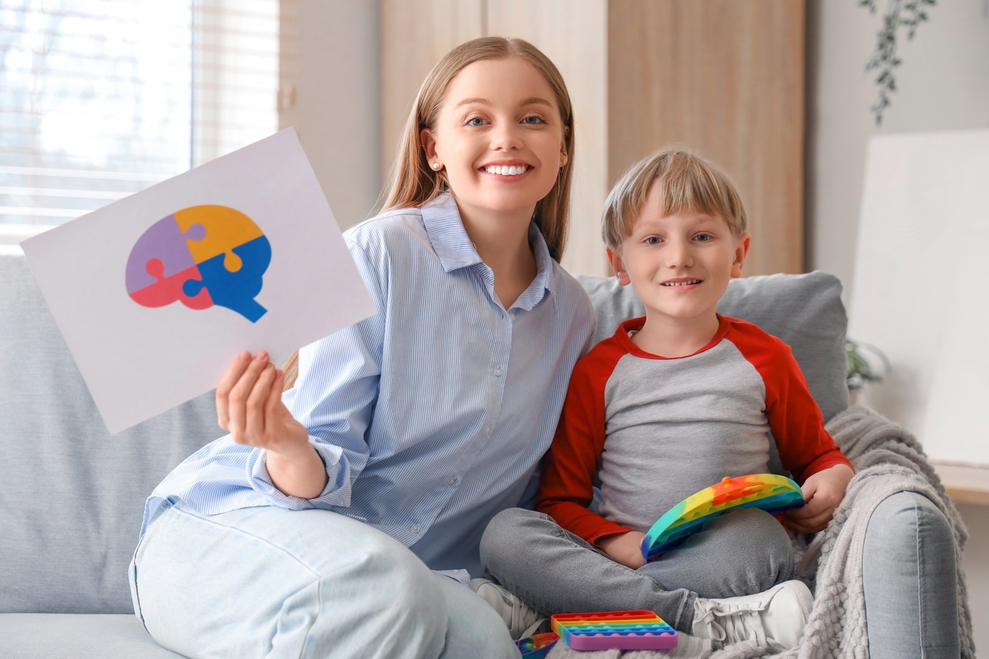 Female psychologist with little boy playing in office.