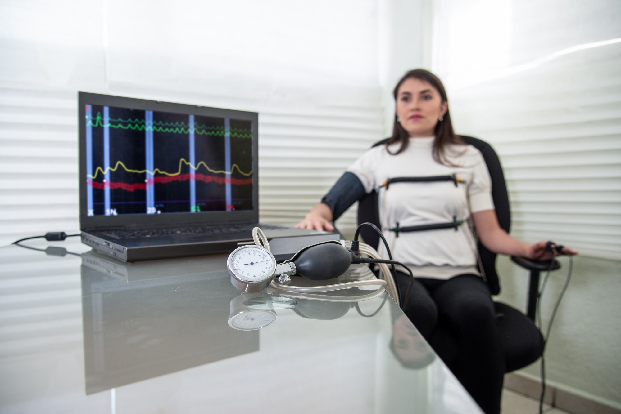 woman in polygraph test with measuring devices to know the truth, scales, hoses and measuring tubes on her body