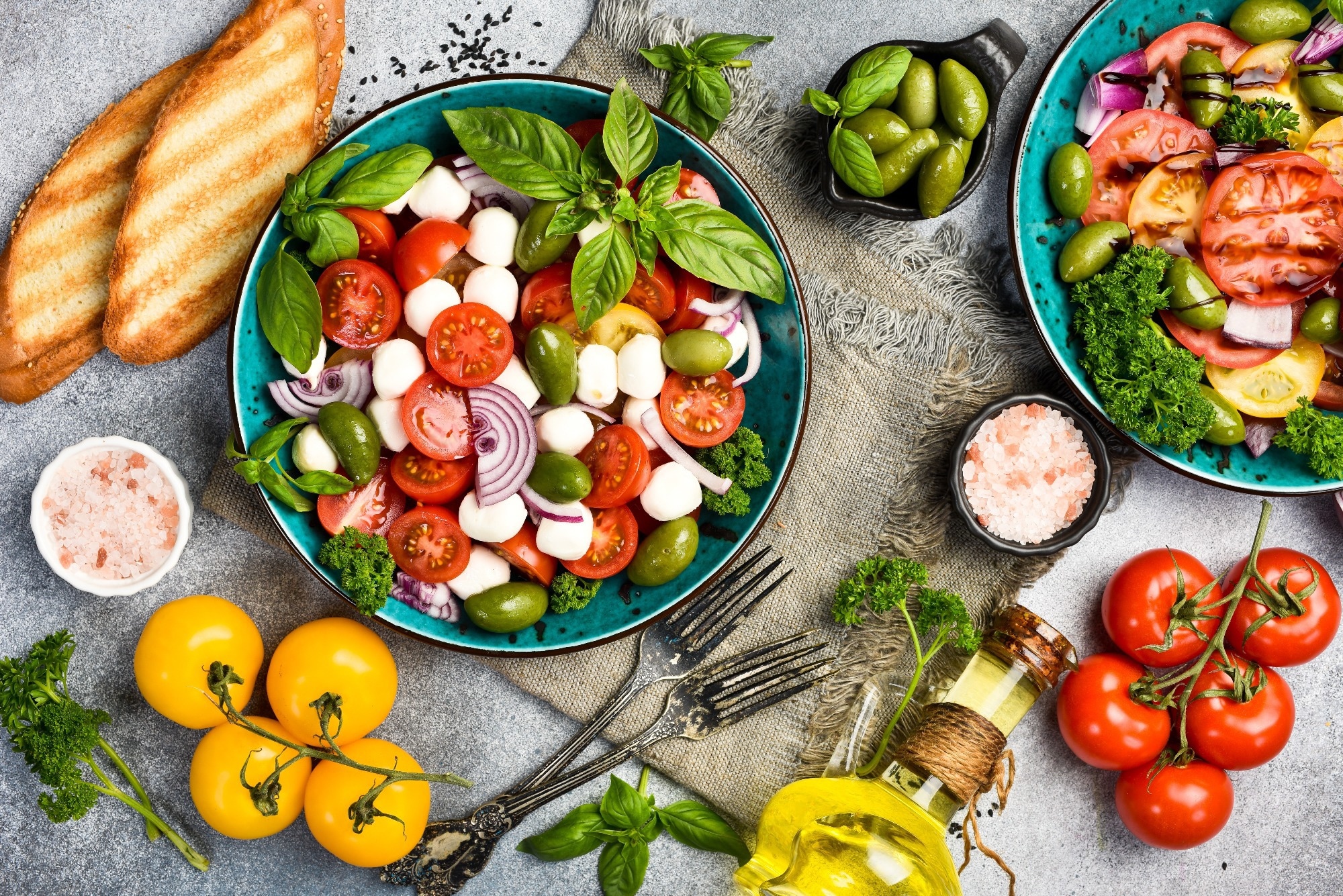 Colorful salad in a bowl: tomatoes, mozzarella cheese, basil and olives. Top view.