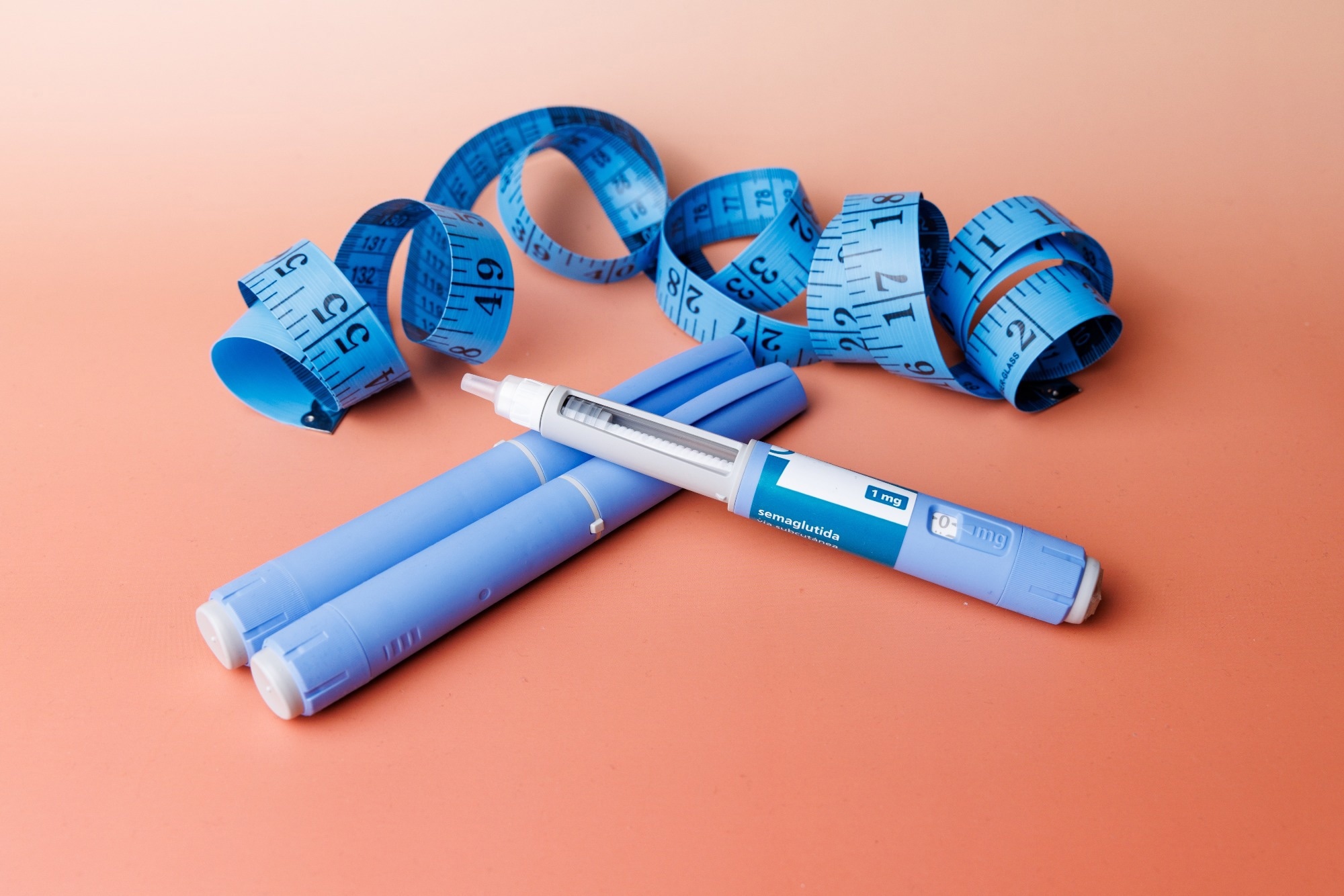GLP-1 medication device next to a tape measure.
