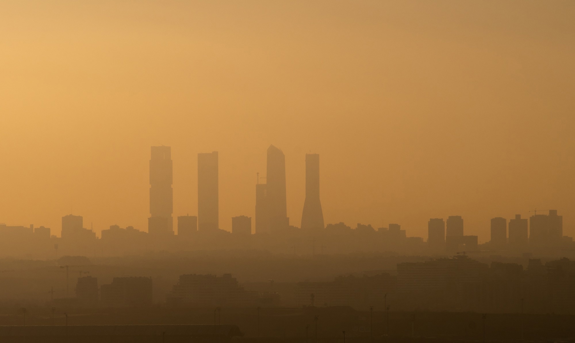 Madrid Business Area skyscrapers with air pollution during sunset. Image Credit: Marcos del Mazo / Shutterstock. Study: Air pollution implies unequal threats to adverse birth outcomes across maternal educational levels in Madrid, Spain