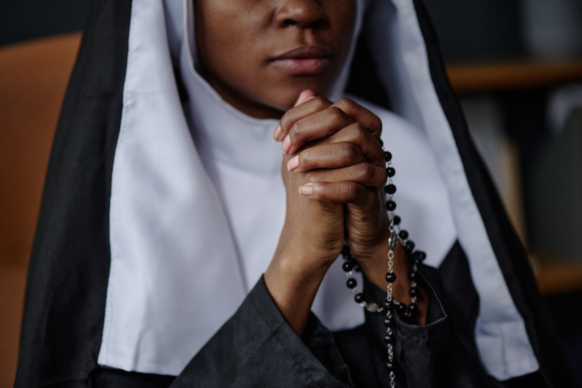 Nun praying with hands and rosary