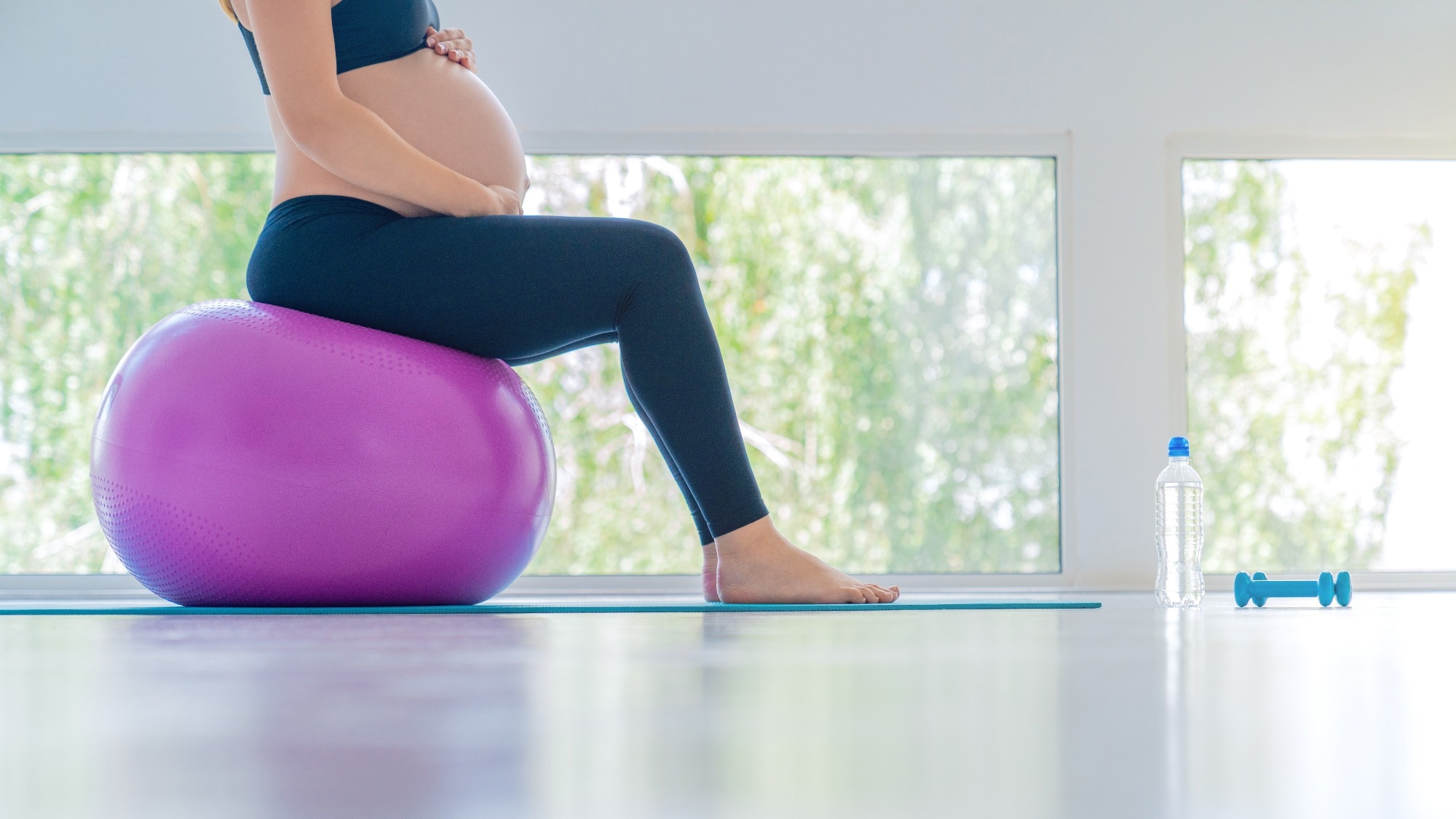 Pregnant woman balancing on exercise ball.
