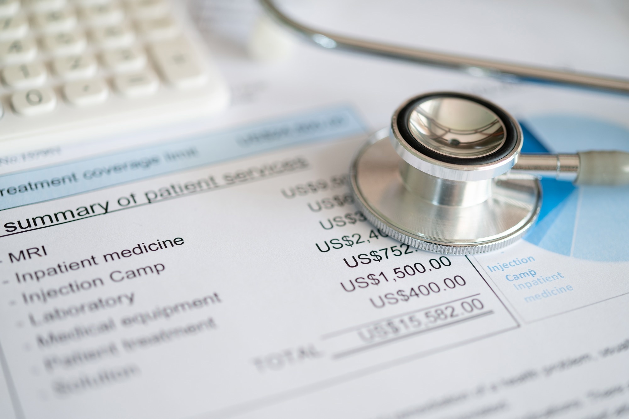 Medical treatment expense on bill statement with calculator and stathoscope.