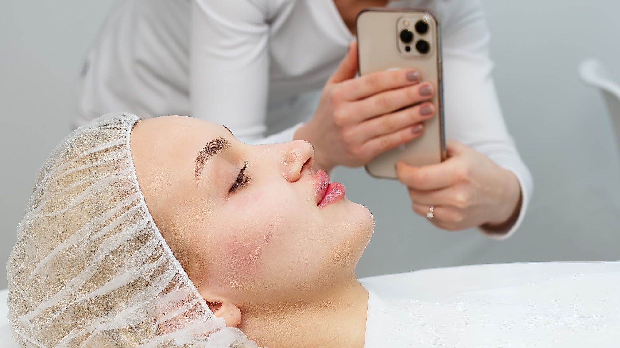 a female doctor takes a photograph of a patient with camera phone
